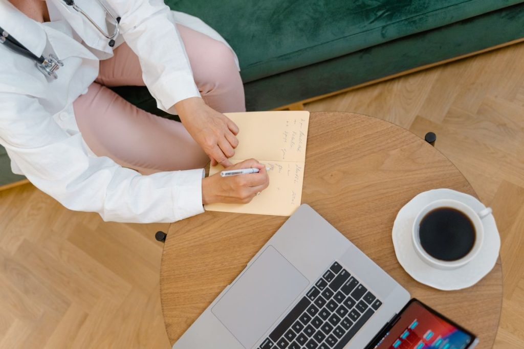 Doctor writing visit notes during a patient consultation